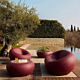 set da giardino Nami di Qeeboo, indian red, foto ambientata con divano, poltrona, tavolino basso e fioriera